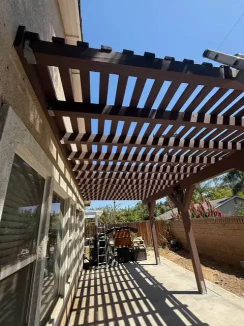 Wood patio cover providing shade over a concrete patio in Rialto, CA, showcasing BPP Construction's residential remodeling services.