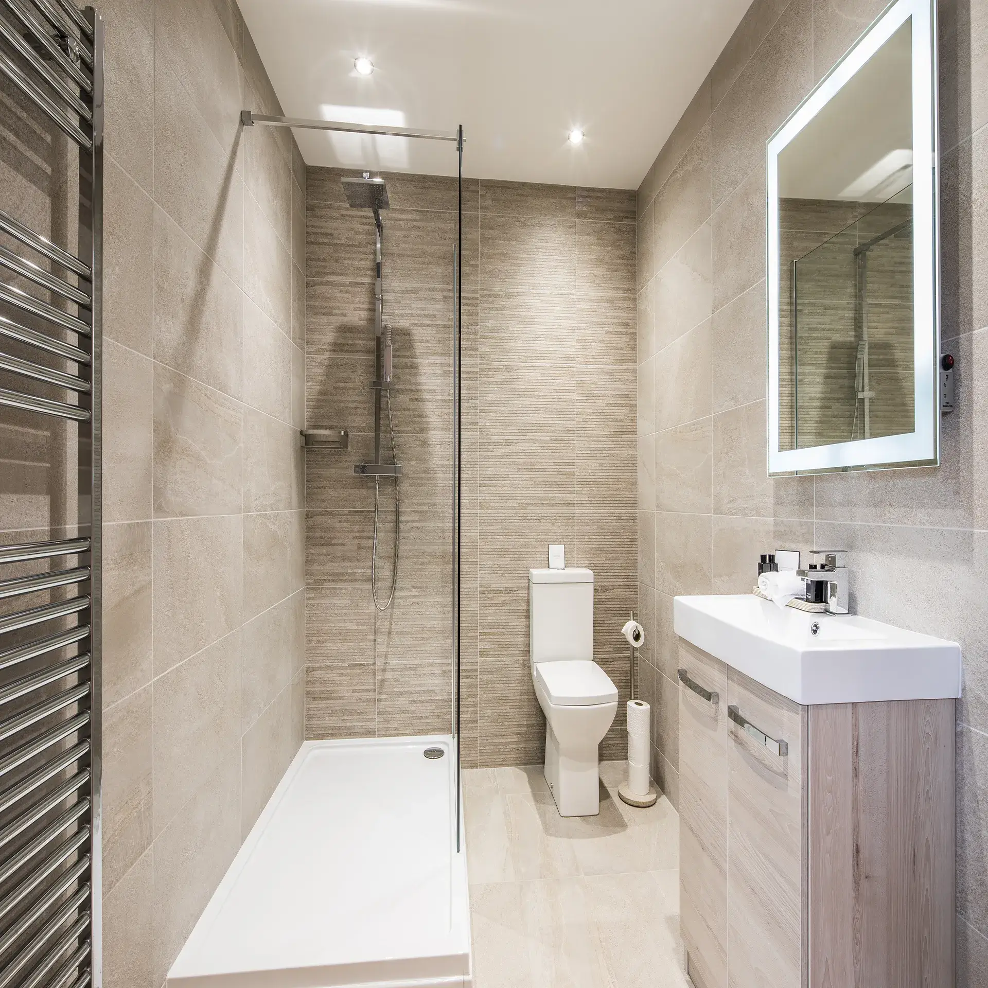 Modern bathroom design featuring a walk-in shower, sleek toilet, and minimalist vanity with storage, showcasing neutral tile and contemporary fixtures.