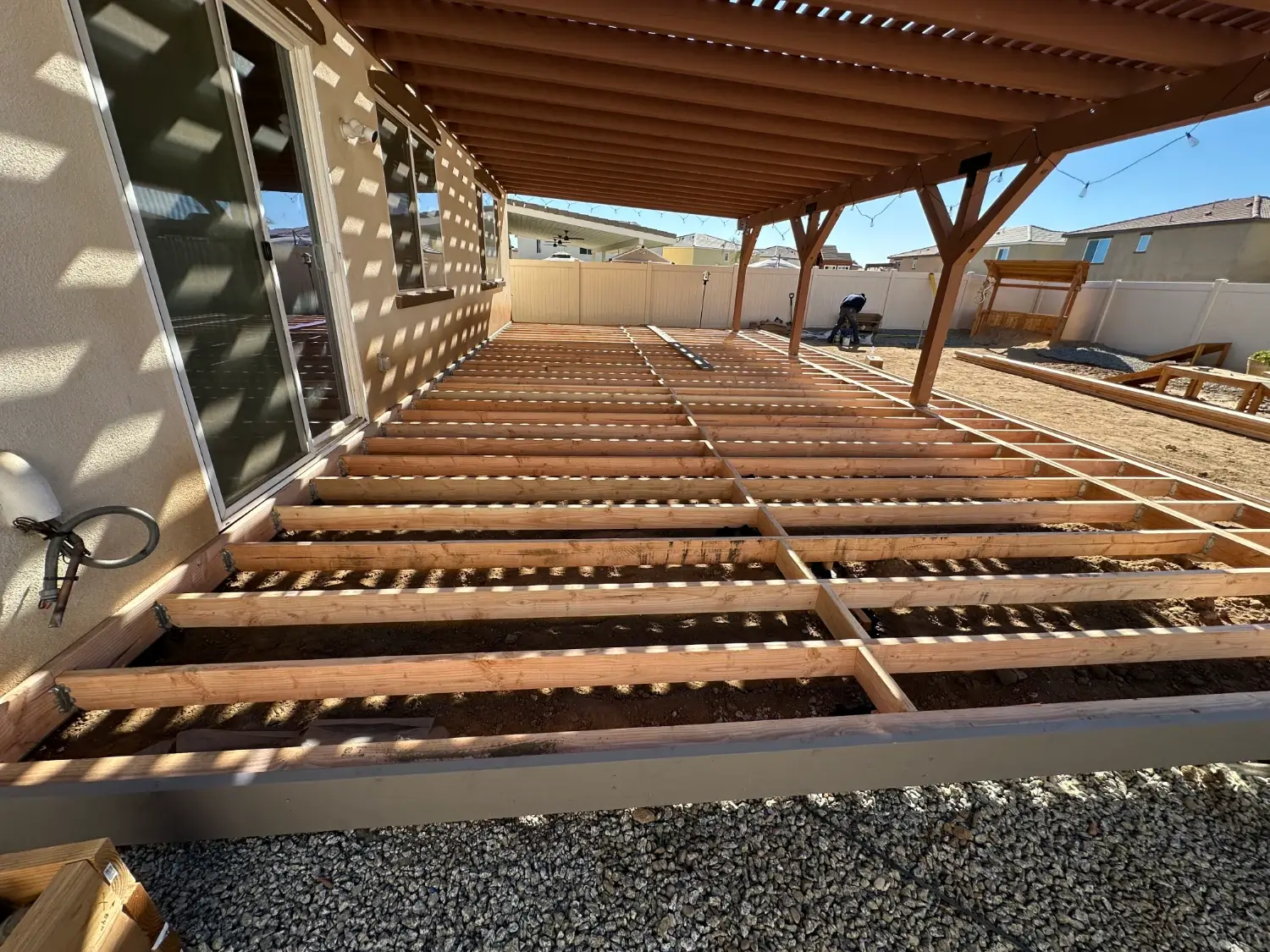 Wood deck framing under a patio cover in Eastvale, showcasing construction progress for a residential remodeling project by BPP Construction.