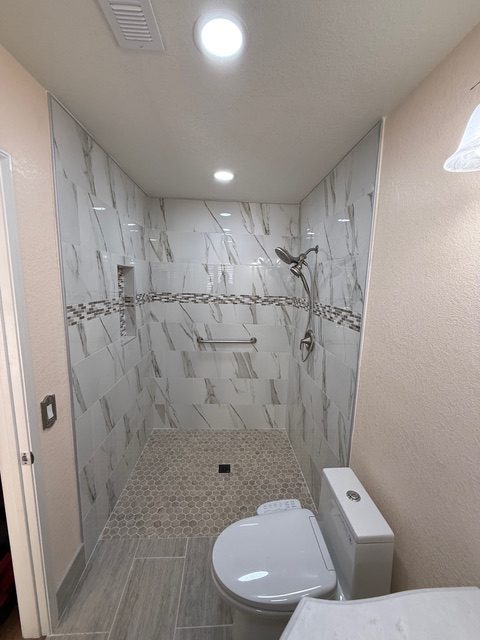 Walk-in shower with marble tile and mosaic accent by BPP Construction for a Menifee, CA homeowner