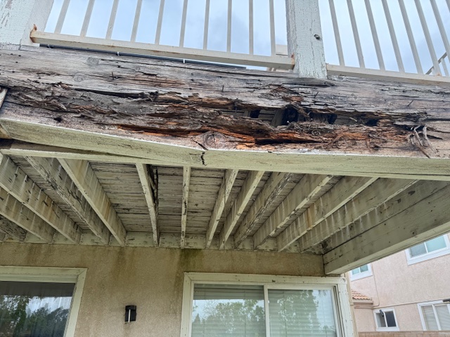 Dry rot damage on wooden porch framing, showcasing deteriorated beams and structural issues, highlighting the need for repair in Riverside County construction project.